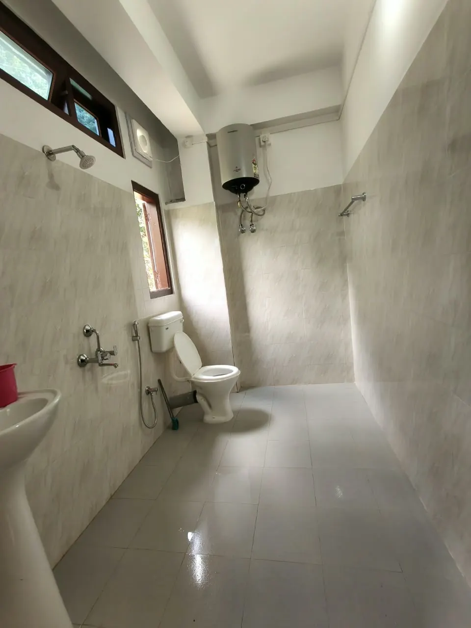 Spacious clean bathroom with geyser and shower